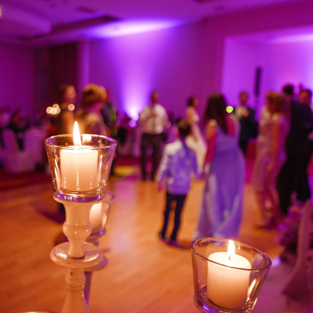 The room bathed in purple uplighting is transformed into an elegant reception