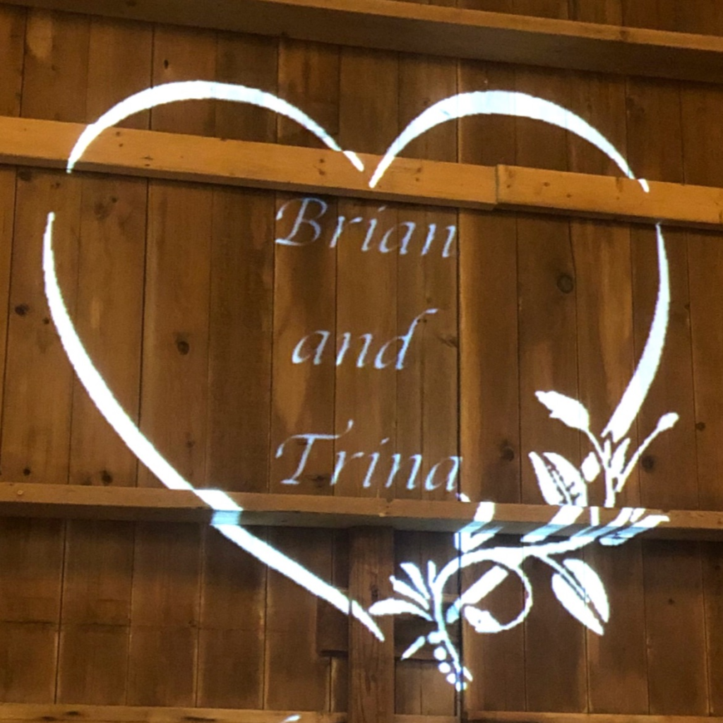 Custom Monogram saying Brian and Tina inside of a heart projected on wall.